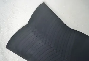 Détail macro d'une robe bandage noire montrant le tissu élastique texturé entrecroisé