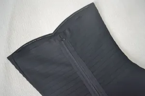 Gros plan sur la fermeture éclair et le tissu bandage d'une robe moulante noire