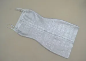 Gros plan sur le tissu métallisé argenté et les fines bretelles de la robe bandage