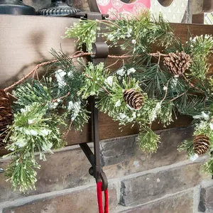 Gros plan d'un support de chaussette de Noël en métal marron rustique sur une cheminée.
