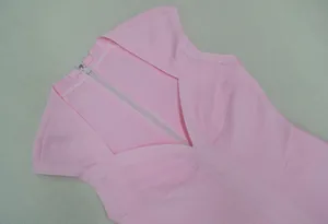 Detail van de ritssluiting en stof van de roze mouwloze nauwsluitende bandagejurk