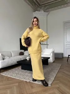 Woman wearing a loose yellow knitted wool blend turtleneck sweater and matching skirt