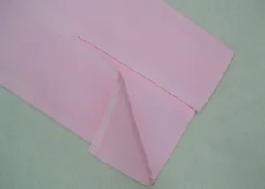 Detailopname van een roze bandagejurk met fijne stoftextuur en zoomstiksel
