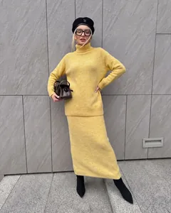 Detail view of a yellow wool blend knitted turtleneck sweater and matching long skirt