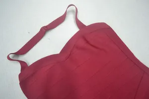 Gros plan des bretelles d'une robe bandage rouge foncé et texture du tissu côtelé