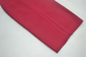 Detail van de hoogwaardige rode bandagejurk met een geribbelde elastische stofstructuur