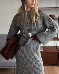 Macro detail view of grey ribbed knit oversized sweater and matching skirt set for women.