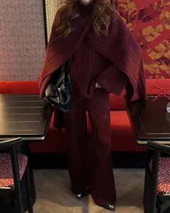 Elegant burgundy three-piece knit set featuring sweater, wide-leg pants, and shawl.