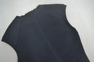 Detailweergave van de verborgen rits en geribbelde textuur op de zwarte bandagejurk