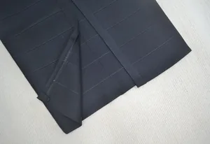 Detailopname van de hoogwaardige gebreide textuur en stiksels van een zwarte bandagejurk