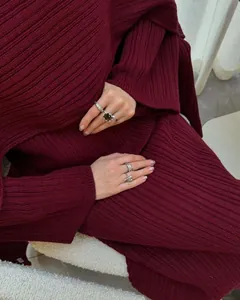 Close-up view of a burgundy ribbed knit three-piece sweater set for women with silver rings