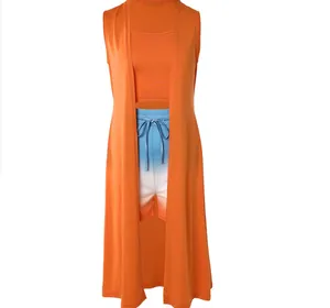 Three-piece set with orange long vest, crop top, and blue gradient shorts.