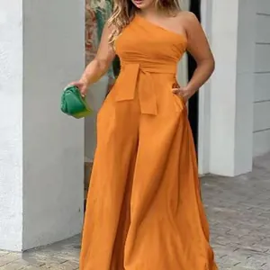 Detailed view of an orange one-shoulder jumpsuit with belted waist and pockets.