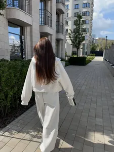 Achteraanzicht van een gezellig wit oversized trainingspak voor dames in een stad