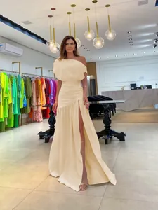 Elegant cream one-shoulder floor-length dress with a sexy high slit for resort wear.