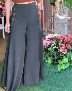 Detail view of high-waisted wide-leg trousers featuring decorative golden side buttons