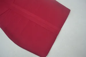 Κοντινό πλάνο της πλεκτής υφής bandage σε ένα σκούρο κόκκινο σέξι bodycon φόρεμα