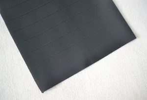 Gros plan sur le tissu bandage noir avec une texture élastique à côtes horizontales.