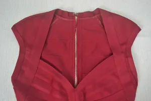 Vue détaillée d'un haut bandage rouge avec une fermeture éclair dorée et un tissu élastique.