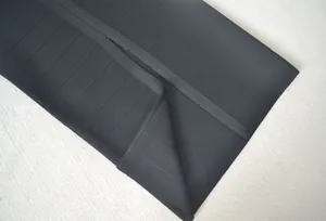 Gros plan de haute qualité montrant la texture côtelée et l'ourlet d'une robe bandage noire