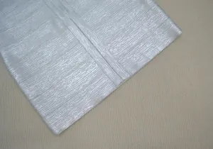 Détail du tissu bandage argenté métallisé avec fini texturé pour une robe de soirée de luxe