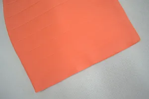 Vue détaillée du tissu d'une robe bandage orange montrant la texture côtelée