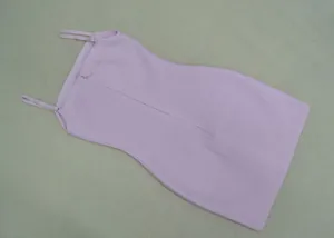 Détail d'une mini-robe bandage rose moulante avec des bretelles spaghetti fines.