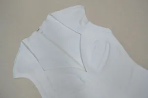 Κοντινό πλάνο λευκού αμάνικου φορέματος bandage με λαιμόκοψη V και λεπτομέρεια φερμουάρ