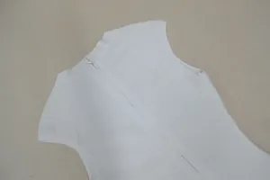 Λεπτομερές κοντινό πλάνο με το πίσω φερμουάρ και το ύφασμα επίδεσμου σε λευκό φόρεμα