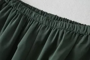 Close-up van de donkergroene elastische tailleband van een casual sportbroek voor dames.