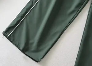 Detailopname van de verstelbare trekkoordzoom en zijstreep van deze groene broek