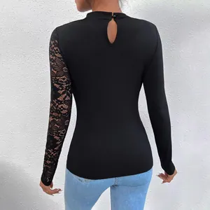 Back view of black mock neck top with one lace sleeve and keyhole button detail