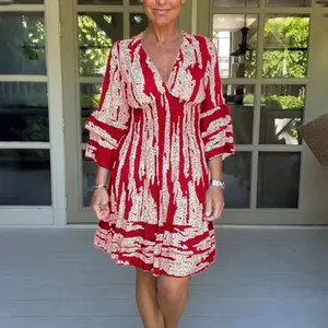 Full view of women's red V-neck printed summer dress with cinched waist and ruffled sleeves