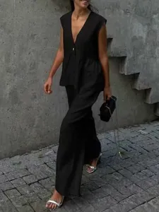 Chic urban street style featuring a black sleeveless vest and matching wide-leg trousers.