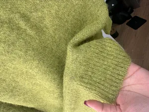 Macro detail view of fuzzy lime green knit fabric showing soft wool blend texture