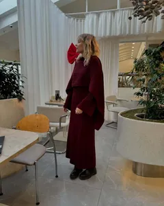 Elegant burgundy three-piece knit sweater set worn in a stylish cafe setting