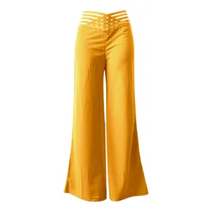 Detalle de pantalones amarillos de pernera ancha con diseño de cintura alta calada.