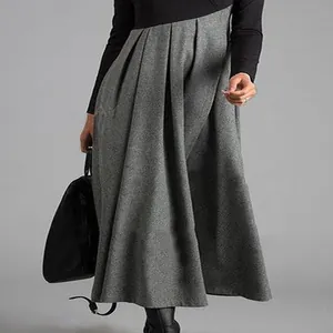 Nahaufnahme eines eleganten plissierten Maxikleides mit langen Ärmeln in Grau und Schwarz.