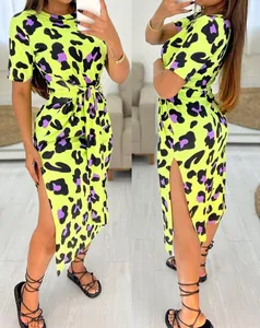 Close-up detail of a vibrant neon leopard print dress featuring a chic side slit