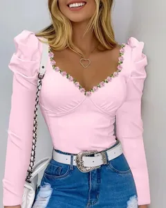 Slim pink puff sleeve V-neck tee with elegant floral neckline trim detail.