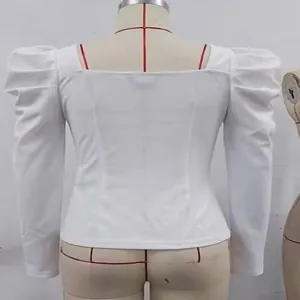 Detail view of a white slim fit top with elegant puff sleeves on a tailor mannequin.