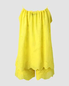Detailansicht eines gelben Baumwoll-Sets mit Lochstickerei-Top und Shorts mit Wellensaum