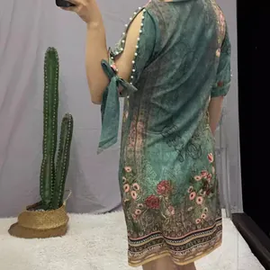 Vintage groene gebloemde jurk met parelmoeren splitmouwen en een losse pasvorm