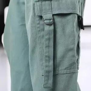 Detail van Amerikaanse cargo broek met een D-ring zak uitgevoerd in een saliegroene twill stof.