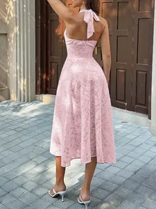 Back view of an elegant pink halter neck pleated midi dress with floral jacquard texture