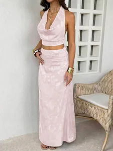 Pale pink cowl neck halter top and long skirt set with textured fabric details.