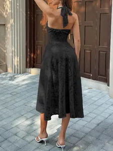 Back view detail of a black halter pleated maxi dress with textured floral pattern.