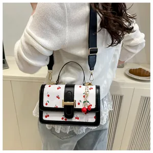 Sweet cherry print crossbody bag with elegant black trim and cute cherry bag charm detail