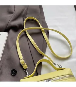 Detailansicht der gelben Lederhandtasche mit verstellbarem langem Schultergurt