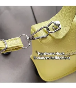 Detailansicht des robusten silbernen Metallhakens und des genarbten Leders einer gelben Tasche